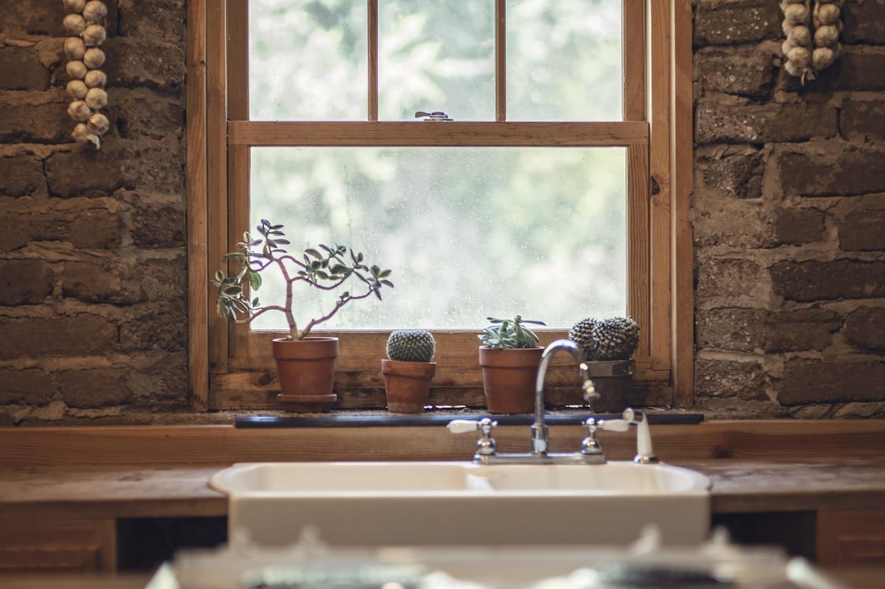 A long kitchen along the stone wall, with an island made from an old workbench.