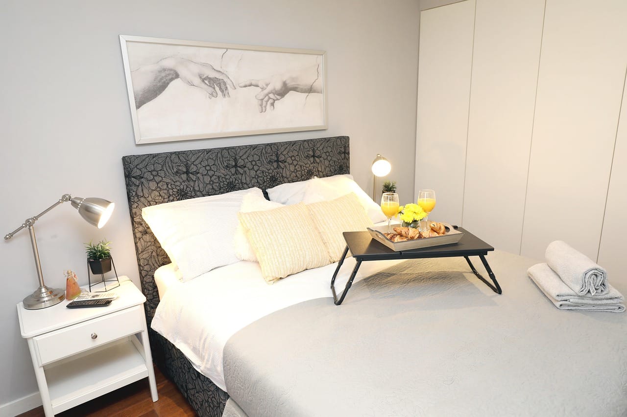 Made up for guests: fresh linen, a tray and a reading lamp.