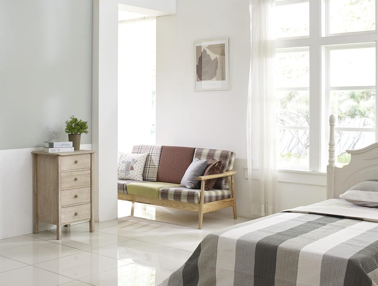 A small linen sofa, plants at three heights and nothing on the floor that does not need to be there.